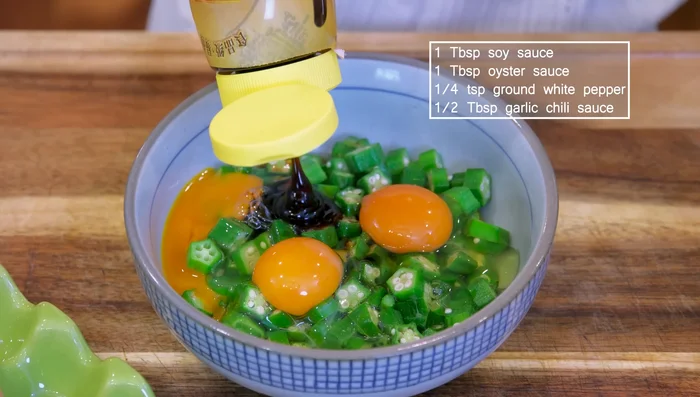 Crack 3 eggs into a bowl. Add soy sauce, oyster sauce, white pepper, and chili sauce. Mix well.