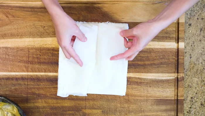 Prepare shrimp wrappers: Cut wrappers in half, fold, and make shreds.