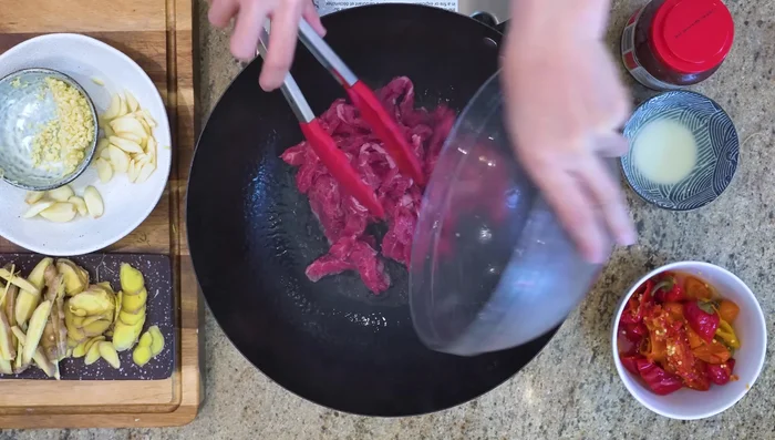 Make pepper steak: Stir-fry beef, add aromatics and sauce.