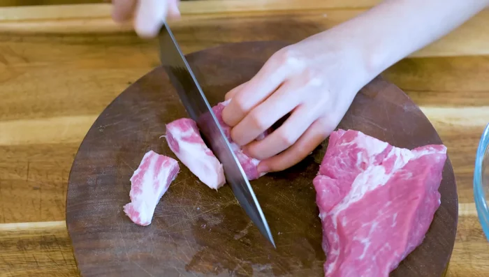 Prepare the pork filling: Grind pork shoulder. Add egg and aromatic water to the ground pork, mixing for 2 minutes in a food processor (or 5 minutes by hand). Drizzle in sesame oil. (330.36)