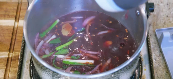 Simmer the gravy: Add the Char Siu gravy to the saucepan, simmer for 5 minutes. Remove aromatics, squeezing out excess liquid.