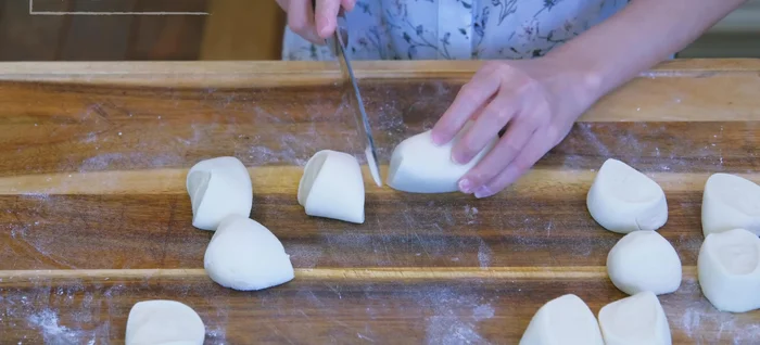 Shape the buns: Roll the dough into a log, divide into 12 pieces (50g each). Flatten each piece, add a portion of filling (30g), and carefully wrap and seal the buns.