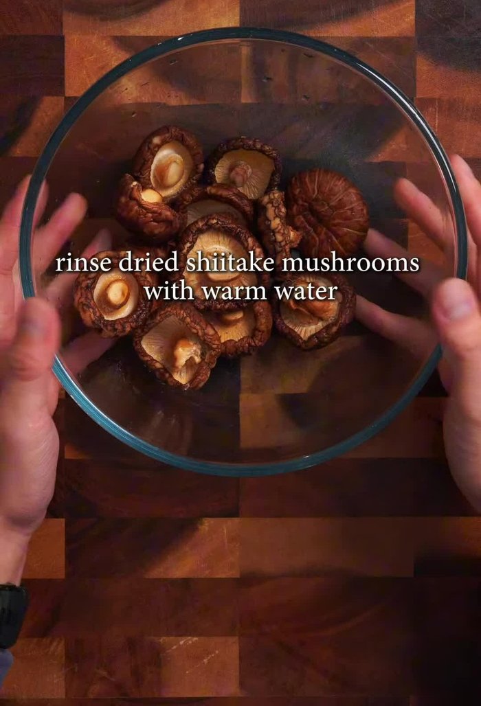 Rinse dried shiitake mushrooms with warm water, discard rinse water, and soak in 1 liter of warm water for 40 minutes or until softened. Trim stems.