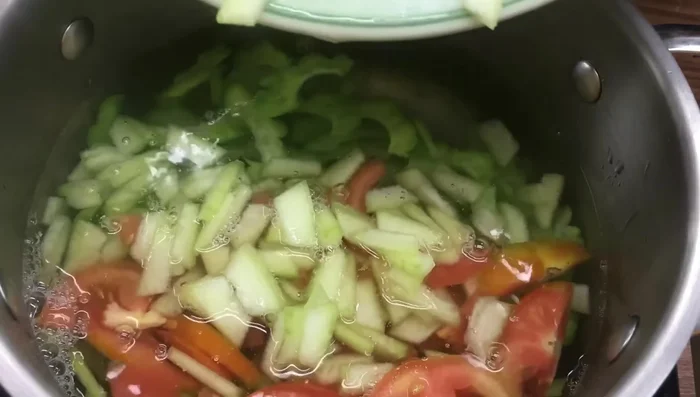Add the sliced wax gourd flesh, bitter melon, and tomato slices to the pot with the boiled wax gourd peel. Stir well and cook for another 10 minutes.