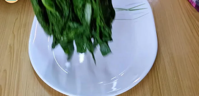 Arrange the drained choy sum on a serving plate and cut into bite-sized pieces using scissors.