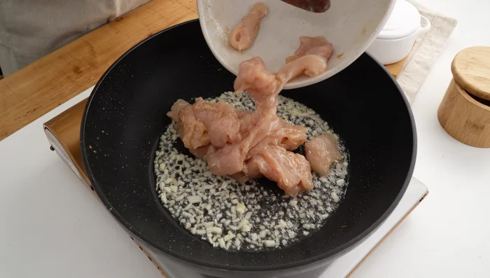 Add the marinated chicken and stir-fry for 2-3 minutes until 80% cooked.