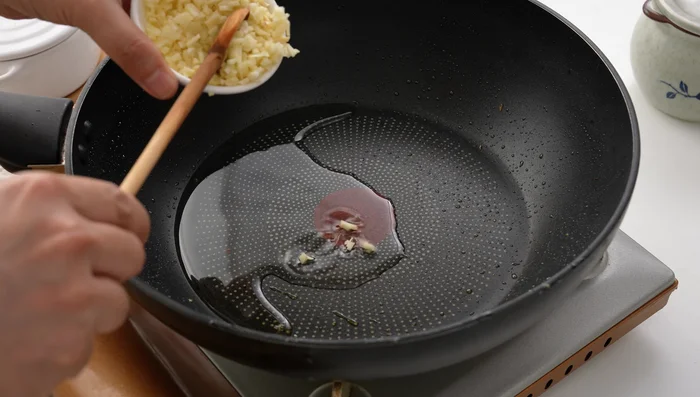 Add more oil to the pan. Add minced garlic and ginger, sauté until fragrant.