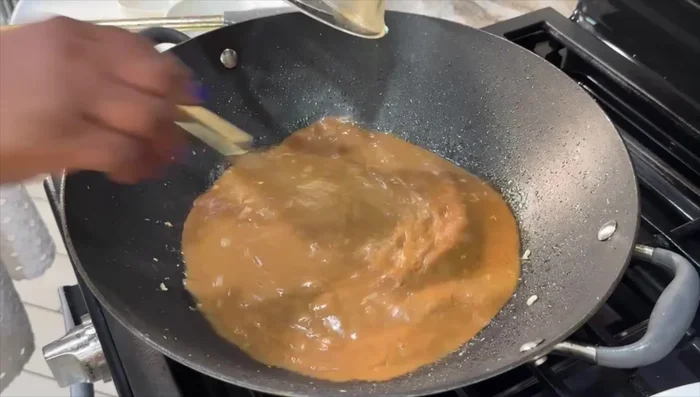 Pour the slurry into the wok and cook until thickened.